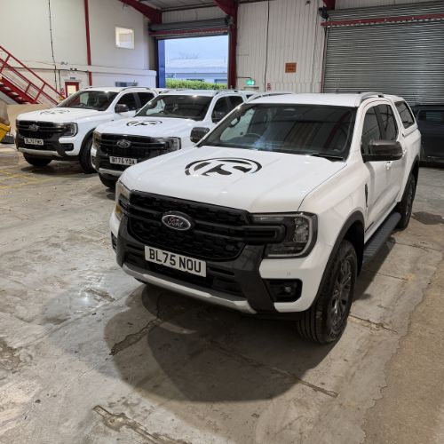 White Ford pickup trucks with fleet graphics