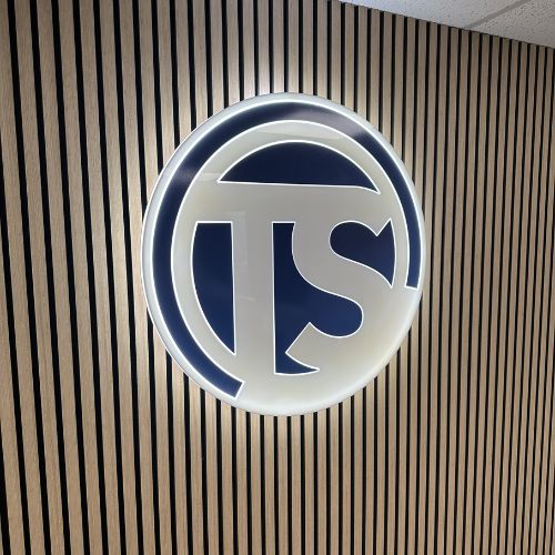 Illuminated TS acrylic logo on wooden slat wall