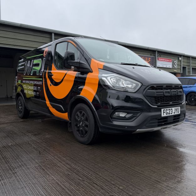 Black van with orange wrap graphics